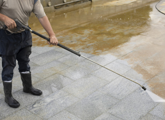 Man washing away the dirt with the help of the pressure of water.